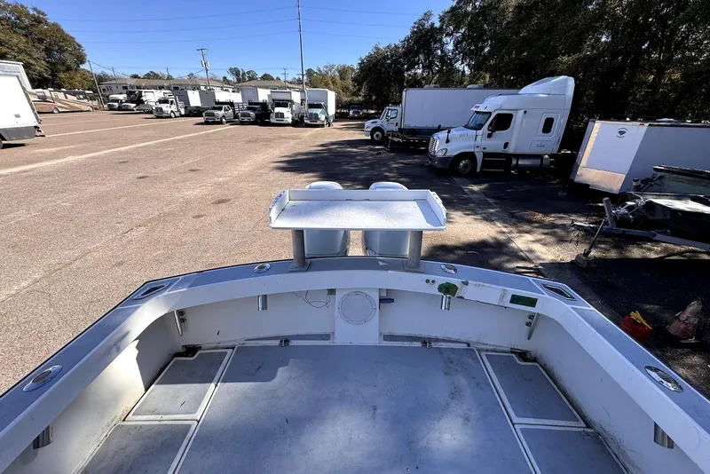 Slide: The Image of 2005 Mirage SF32 Center Console boat in a parking lot with trucks. - 15