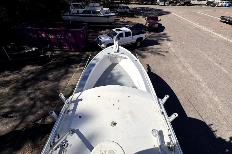 Slide: The Image of 2005 Mirage SF32 Center Console boat parked in a lot with trucks nearby. - 23