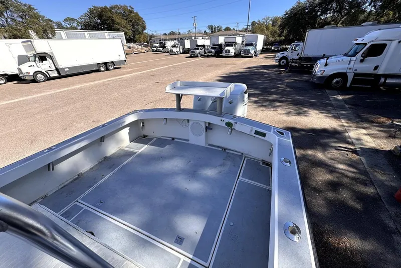 Slide: The Image of 2005 Mirage SF32 Center Console boat in parking lot with trucks in background. - 24
