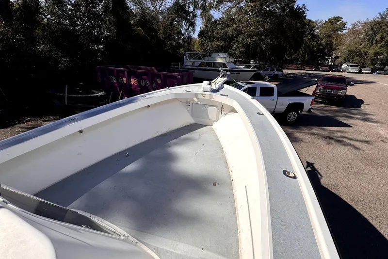 Slide: The Image of 2005 Mirage SF32 Center Console boat on trailer, parked near trucks and trees. - 28