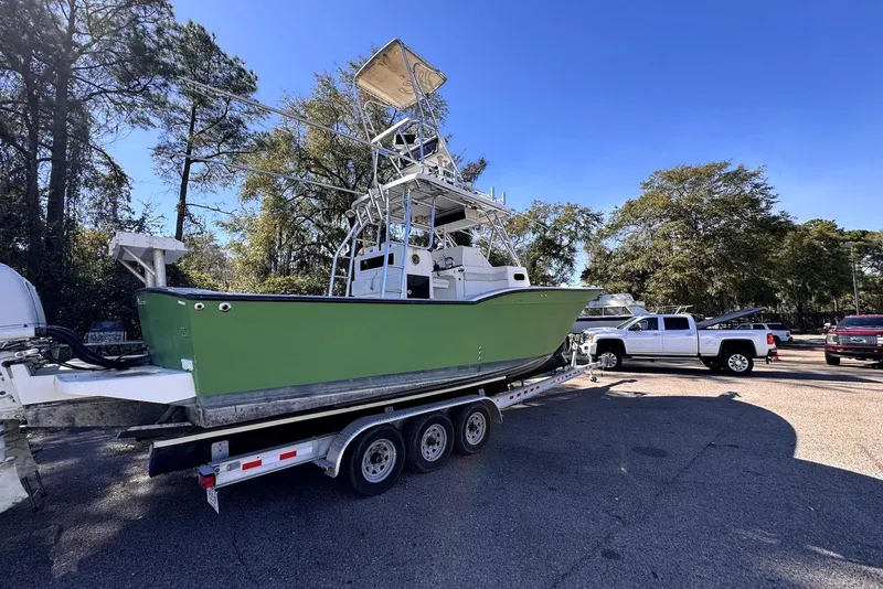 Slide: The Image of 2005 Mirage SF32 Center Console boat on trailer, parked outdoors under clear blue sky. - 8