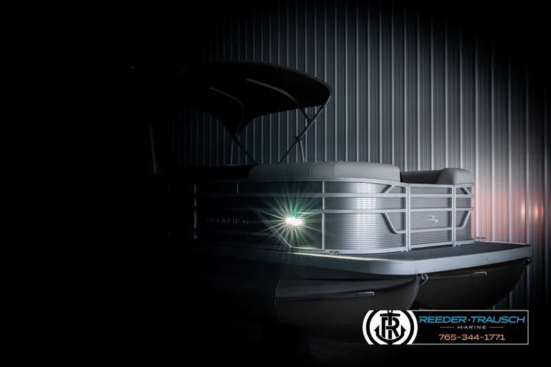 Slide: The Image of 2026 Bennington 22 SSRSF pontoon boat in dimly lit showroom, highlighting sleek design. - 4