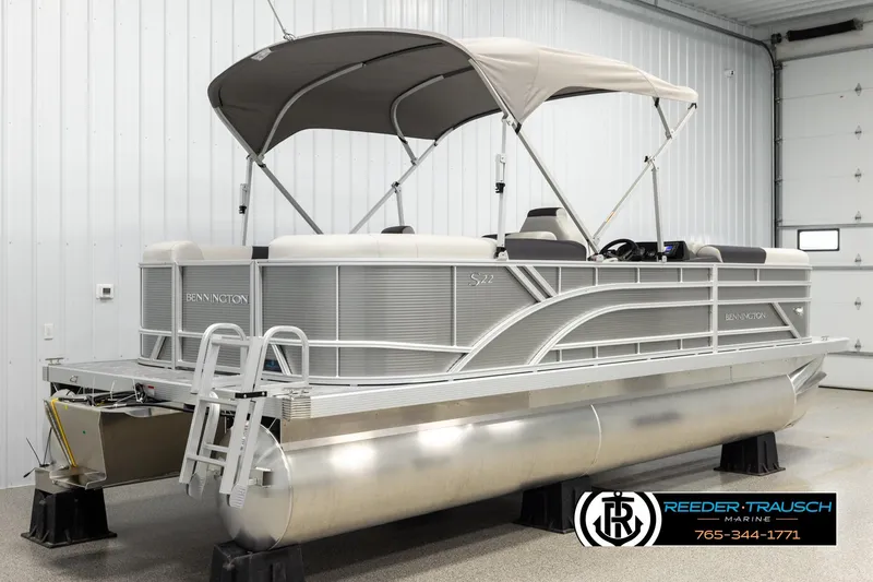 Slide: The Image of 2026 Bennington 22 SSRSF pontoon boat in showroom, featuring sleek design and canopy. - 6