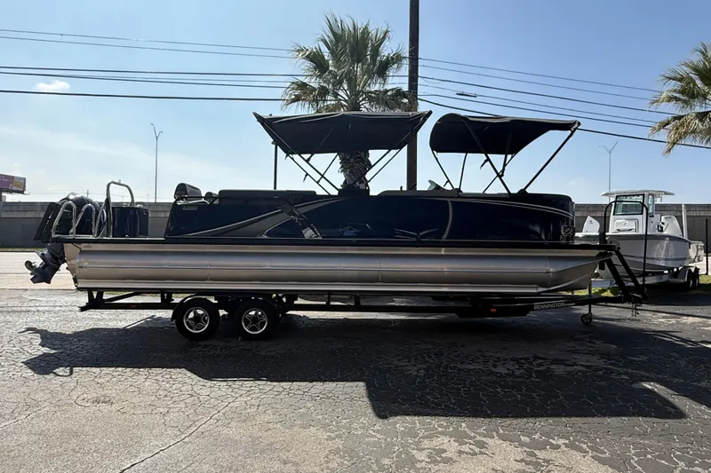 The Image of 2026 Avalon LSZ 25 Quad Lounge pontoon boat on trailer, parked outdoors. - 0