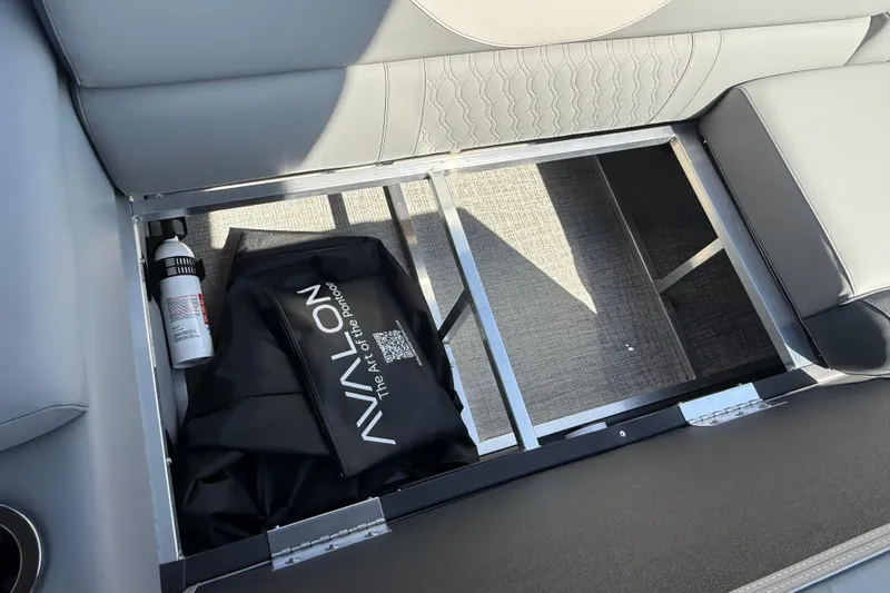 Slide: The Image of 2026 Avalon LSZ 25 Quad Lounge storage compartment with fire extinguisher and branded bag. - 7