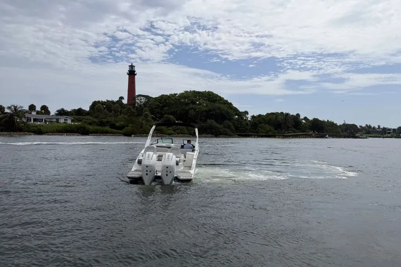 Slide: The Image of A Sea Ray SDX 290 Outboard boat on calm waters, with a lighthouse in the background. - 11