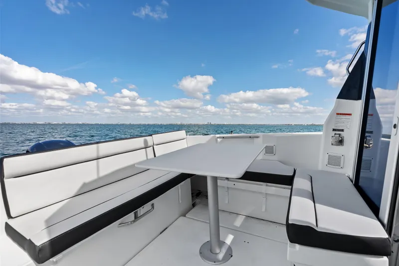 Slide: The Image of 2019 Jeanneau NC 795 boat interior with seating and table, overlooking the ocean. - 11
