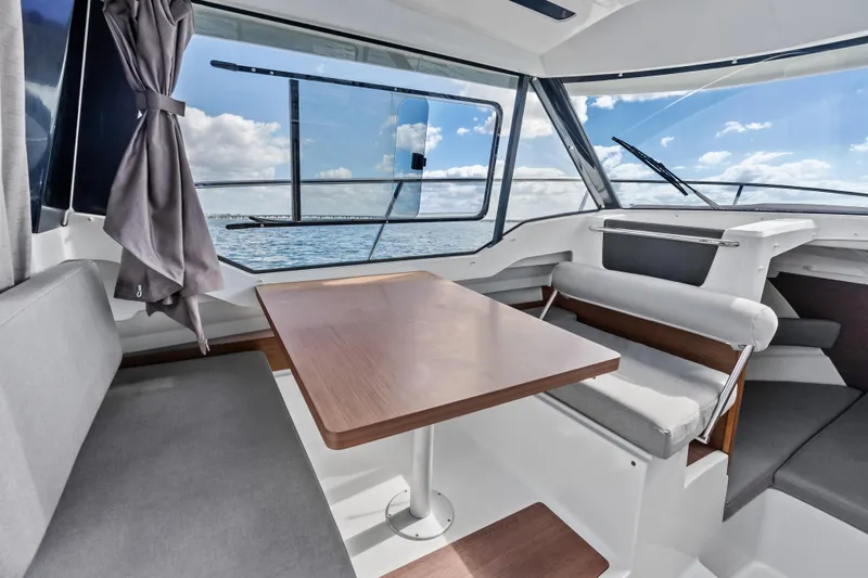 Slide: The Image of Interior of 2019 Jeanneau NC 795 boat with seating and table, overlooking the ocean. - 15