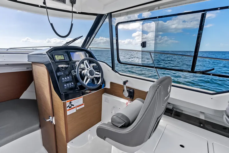 Slide: The Image of 2019 Jeanneau NC 795 boat interior with steering wheel, dashboard, and ocean view. - 17
