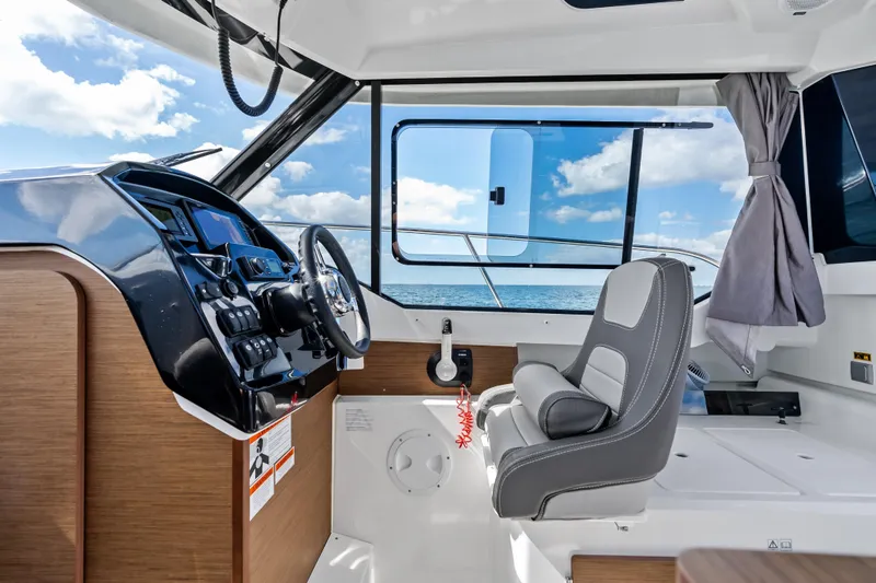 Slide: The Image of Interior of 2019 Jeanneau NC 795 boat with steering wheel and ocean view. - 18