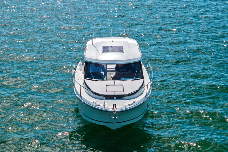Slide: The Image of 2019 Jeanneau NC 795 boat on sparkling blue water, front view. - 2