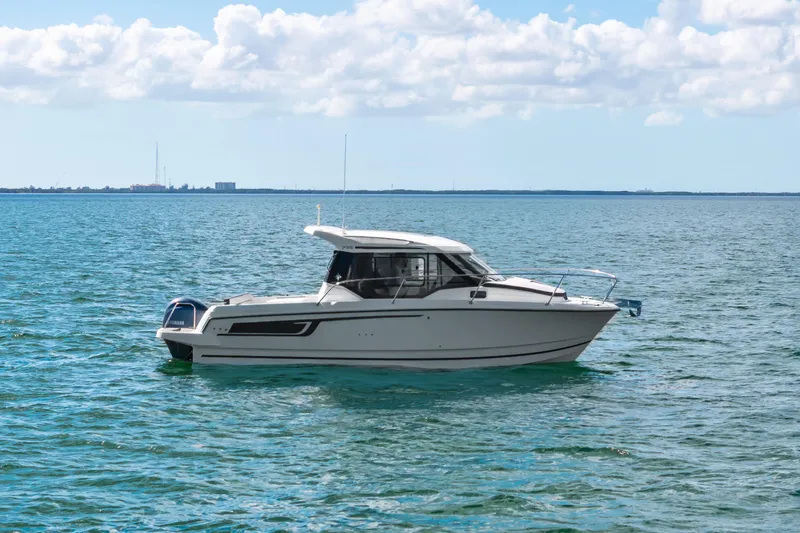 Slide: The Image of 2019 Jeanneau NC 795 boat on calm blue water under a partly cloudy sky. - 4