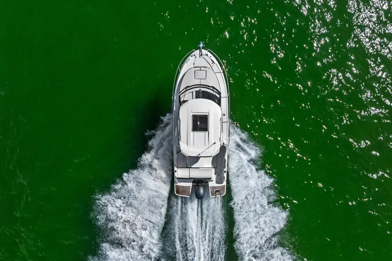 Slide: The Image of Aerial view of 2019 Jeanneau NC 795 motorboat cruising on vibrant green water. - 8