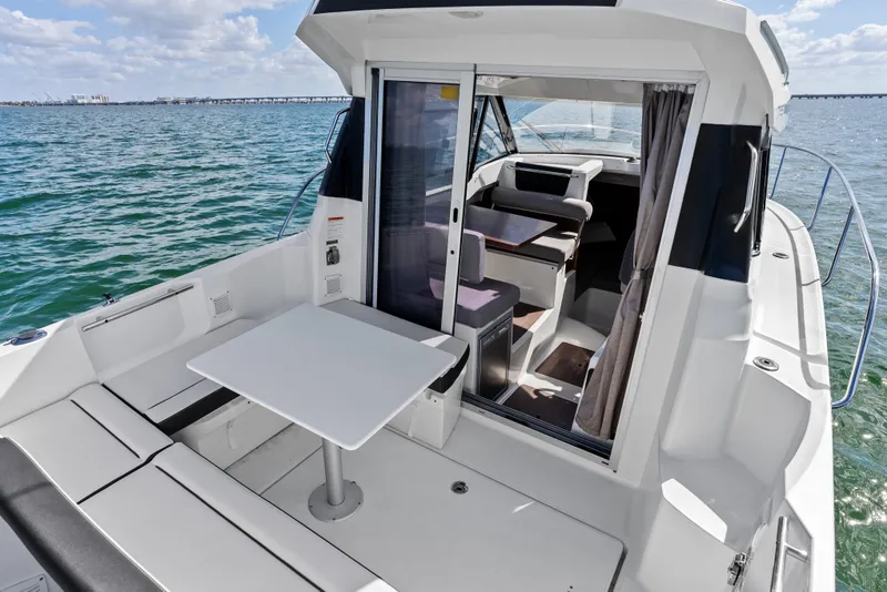 Slide: The Image of 2019 Jeanneau NC 795 boat interior with seating and table on open water. - 9