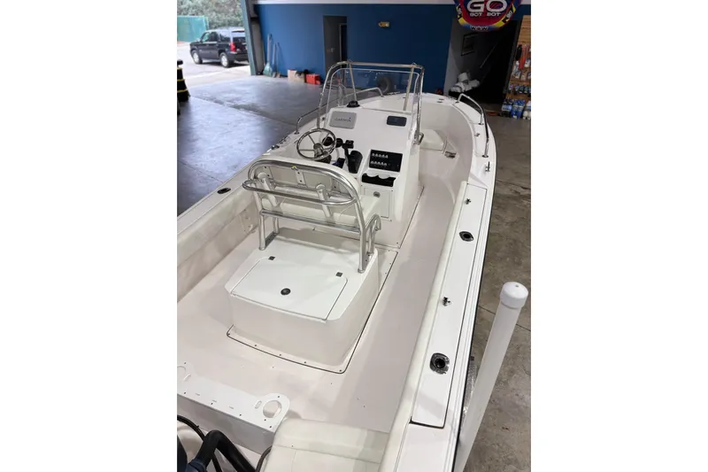 Slide: The Image of 2021 Edgewater 188CC boat interior with console and seating in a garage setting. - 9