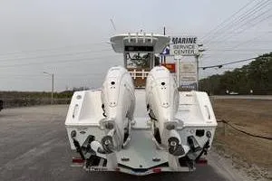 Slide: The Image of 2026 Sea Hunt Gamefish 25 boat with dual engines at a marine service center. - 3