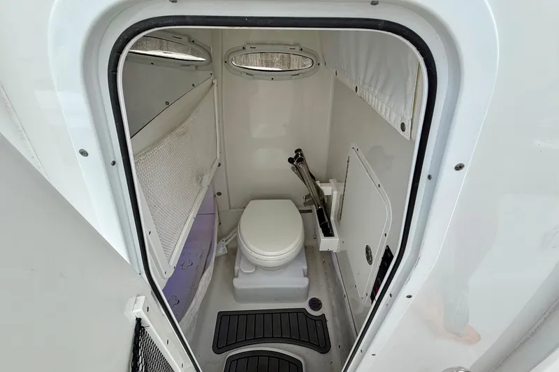 Slide: The Image of 2022 Sea Hunt Ultra 265 SE boat interior with compact marine toilet. - 13