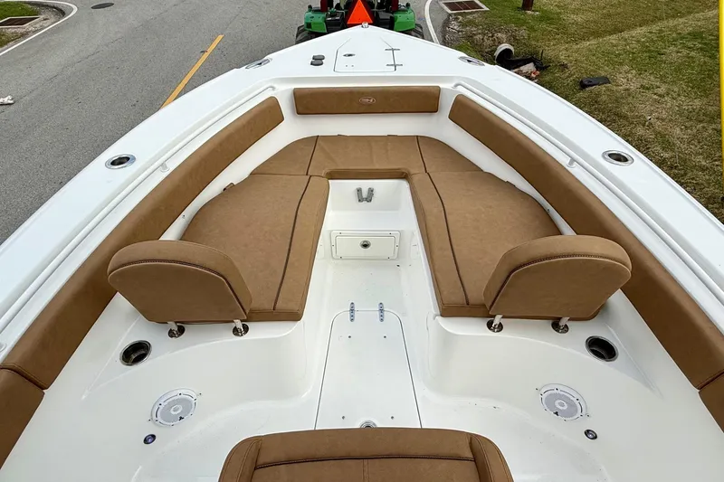 Slide: The Image of 2022 Sea Hunt Ultra 265 SE boat with tan cushioned seating and white deck. - 14