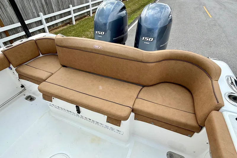 Slide: The Image of 2022 Sea Hunt Ultra 265 SE boat with tan seating and dual Yamaha 150 engines. - 7