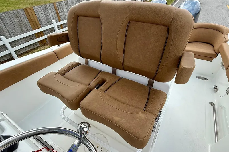 Slide: The Image of 2022 Sea Hunt Ultra 265 SE boat with brown cushioned seating and steering wheel. - 9