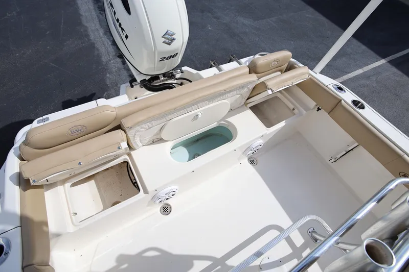 Slide: The Image of 2015 Key West 219 FS boat interior with Suzuki 200 engine, featuring seating and storage compartments. - 10