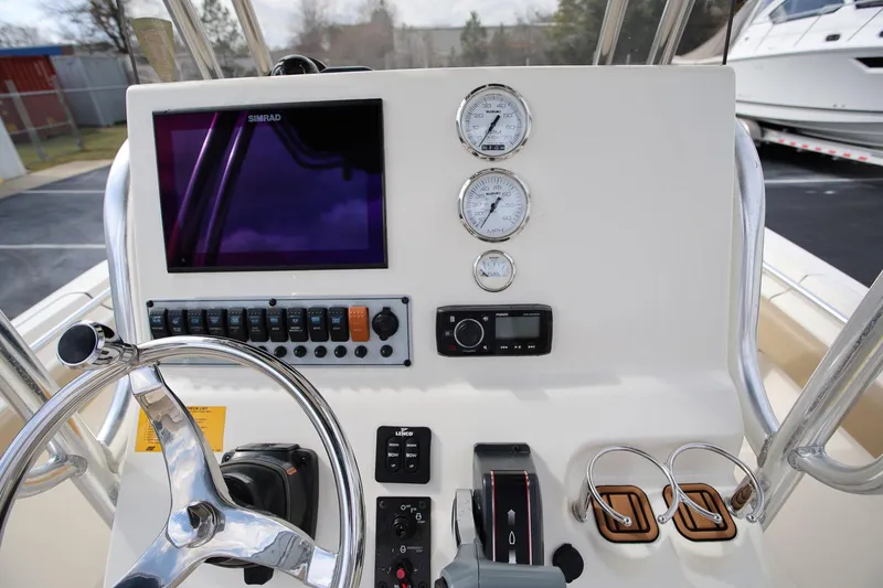 Slide: The Image of 2015 Key West 219 FS boat dashboard with steering wheel, gauges, and controls. - 14