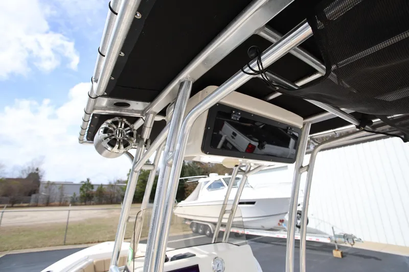 Slide: The Image of 2015 Key West 219 FS boat with T-top and speaker system, docked outdoors. - 15