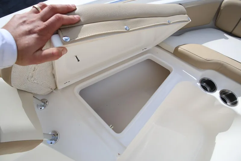 Slide: The Image of 2015 Key West 219 FS boat storage compartment with beige seating and cup holders. - 18