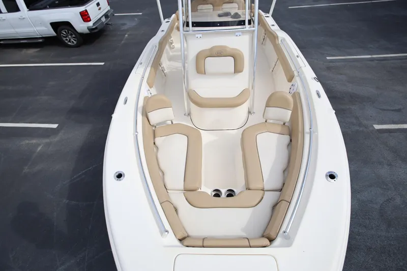 Slide: The Image of 2015 Key West 219 FS boat interior with beige seating, parked in a lot. - 19