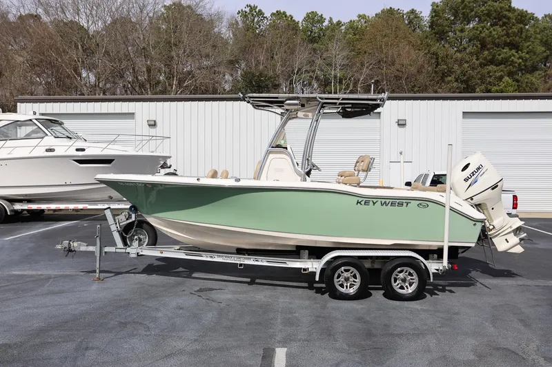 Slide: The Image of 2015 Key West 219 FS boat on trailer, parked outdoors near storage facility. - 4