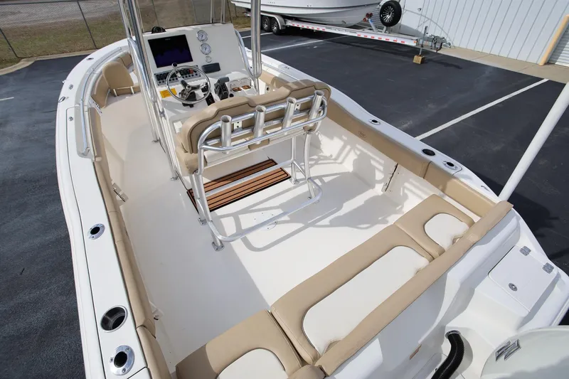 Slide: The Image of 2015 Key West 219 FS boat interior with seating and console, parked outdoors. - 6