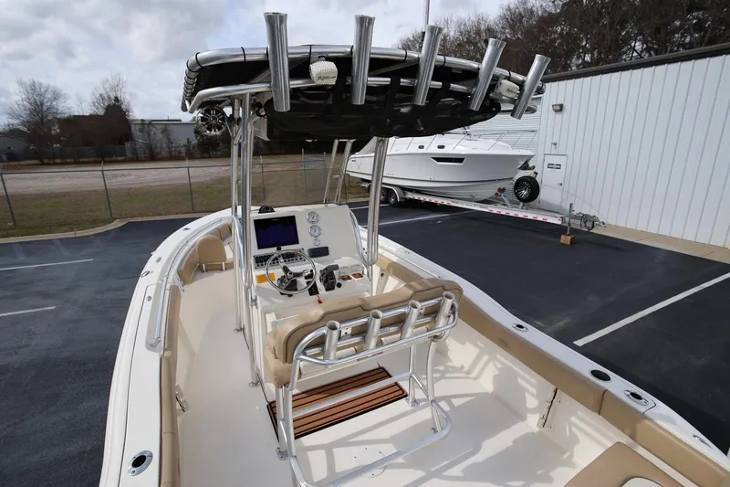 Slide: The Image of 2015 Key West 219 FS boat interior with helm, seating, and rod holders in a parking lot. - 7