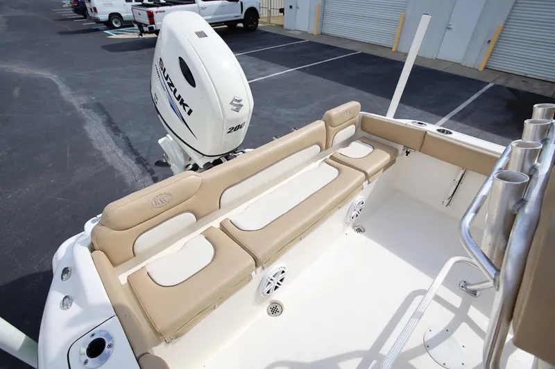 Slide: The Image of 2015 Key West 219 FS boat interior with Suzuki 200 engine, beige seating, and rod holders. - 8