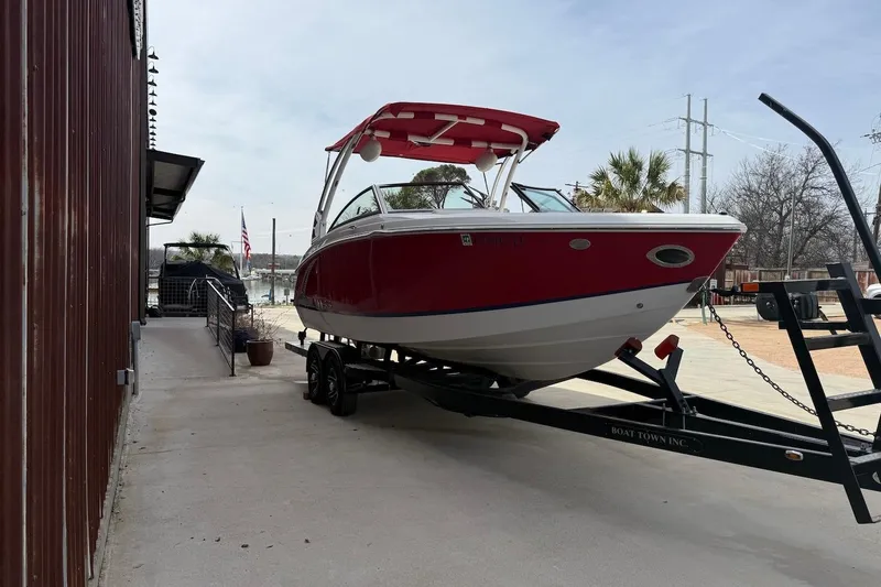 Slide: The Image of 2017 Cobalt R3 WSS Surf boat on trailer, red and white, parked outdoors. - 2