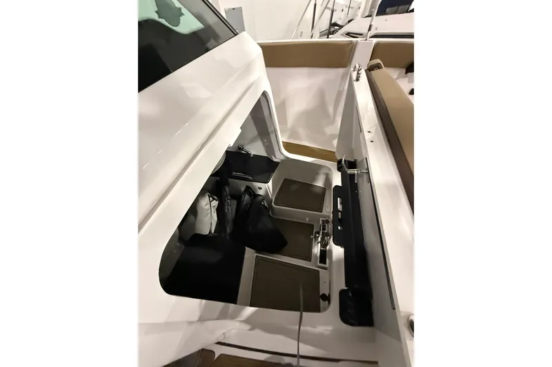 Slide: The Image of 2026 Monterey Elite 25 SD boat interior storage compartment with seating area. - 9