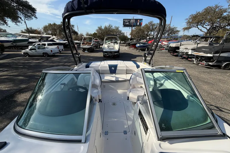 Slide: The Image of 2019 Chaparral 21 H2O Surf boat in a marina, surrounded by other boats. - 12