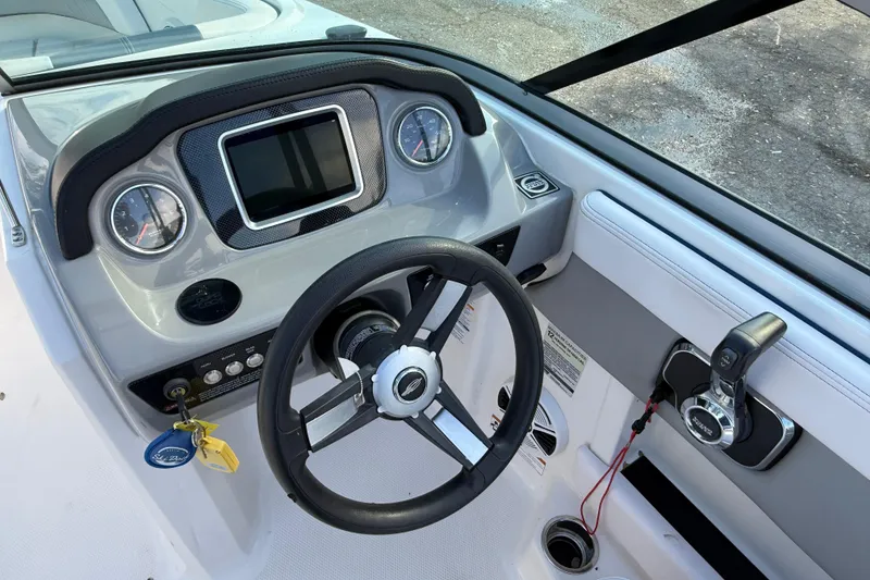 Slide: The Image of 2019 Chaparral 21 H2O Surf boat dashboard with steering wheel and control panel. - 9