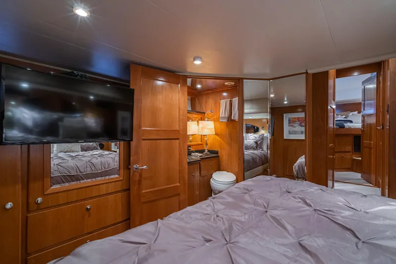 Slide: The Image of Luxurious 2006 Navigator 5100 yacht bedroom with TV, wood paneling, and cozy bedding. - 34