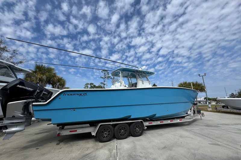 Slide: The Image of 2016 Freeman 37VH boat on trailer under a partly cloudy sky. - 11