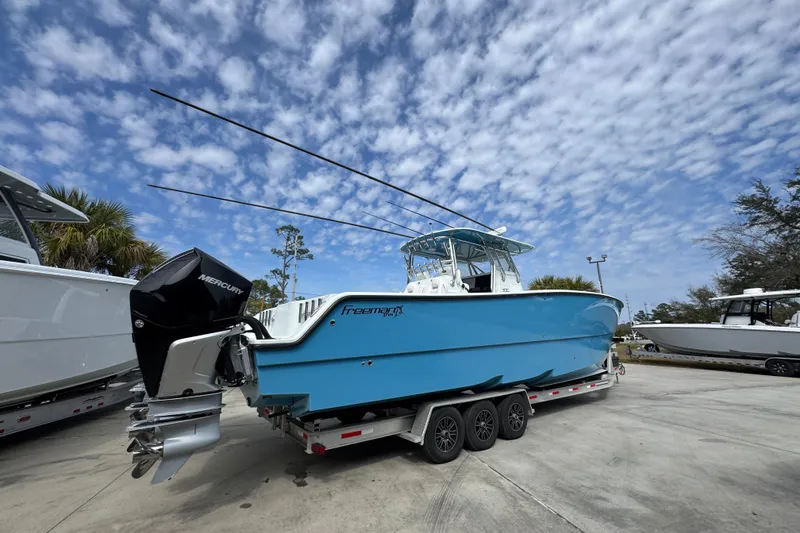 Slide: The Image of Blue 2016 Freeman 37VH boat on trailer under cloudy sky. - 12