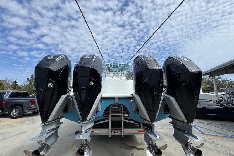 Slide: The Image of Four powerful outboard engines on a 2016 Freeman 37VH boat under a partly cloudy sky. - 15