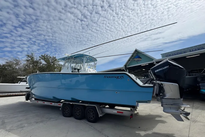 Slide: The Image of 2016 Freeman 37VH boat on trailer with Mercury engines, under a cloudy sky. - 17