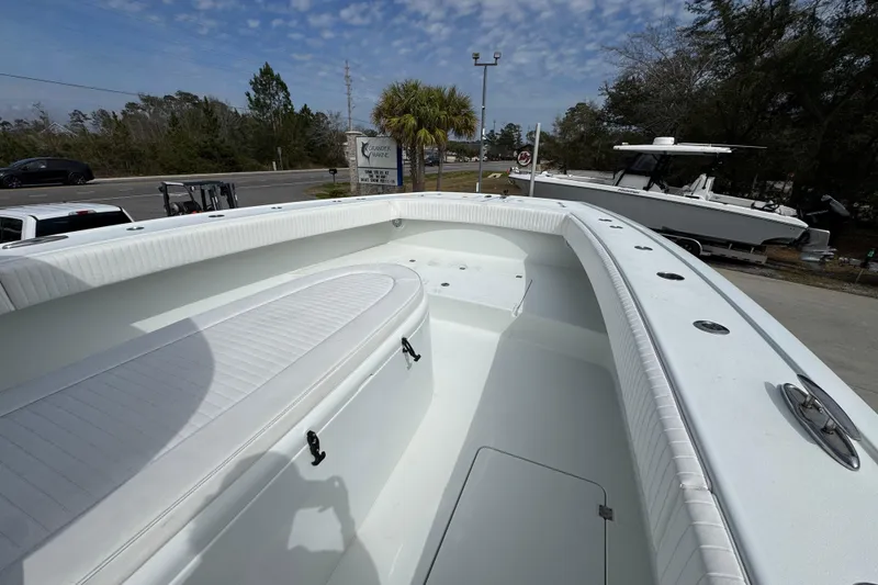 Slide: The Image of 2016 Freeman 37VH boat with spacious deck and seating, parked outdoors under a blue sky. - 24