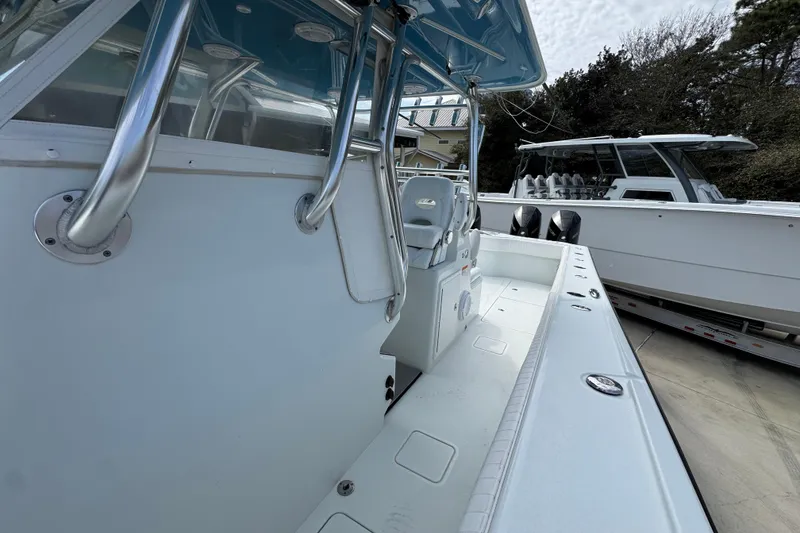 Slide: The Image of 2016 Freeman 37VH boat interior with seating and controls, docked beside another vessel. - 25