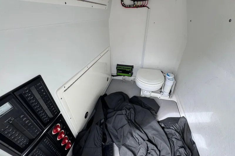 Slide: The Image of Interior of a 2016 Freeman 37VH boat featuring a compact toilet and control panels. - 27