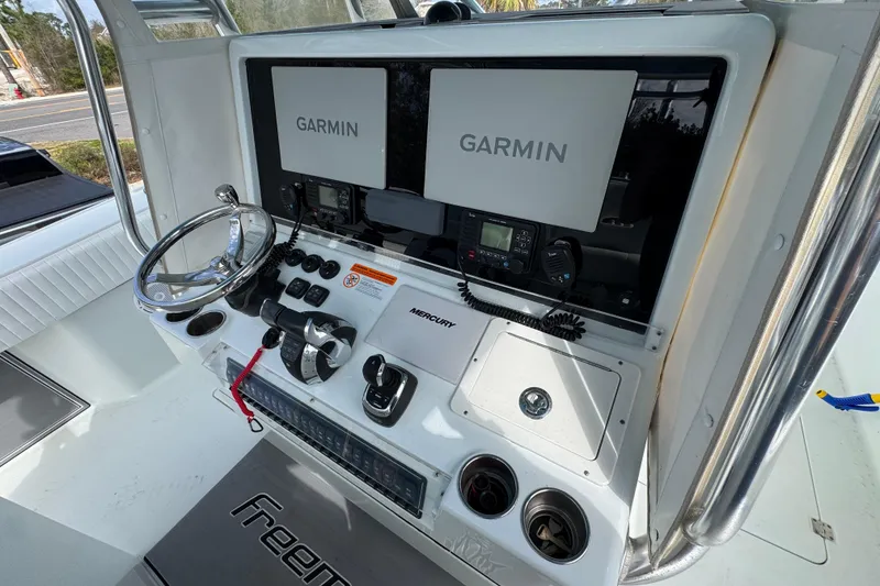 Slide: The Image of Freeman 37VH 2016 boat dashboard with Garmin displays and Mercury controls. - 34