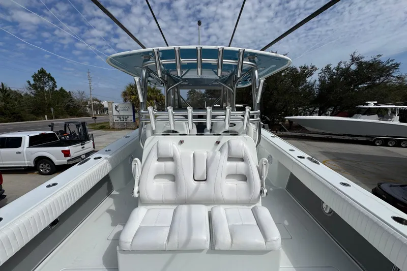 Slide: The Image of 2016 Freeman 37VH boat with white seating and T-top under a partly cloudy sky. - 37