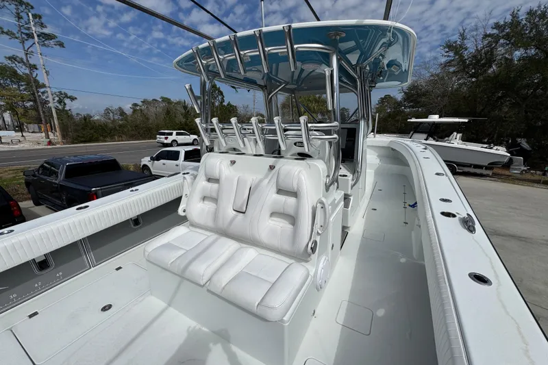 Slide: The Image of 2016 Freeman 37VH boat with white seating and rod holders, docked outdoors. - 38