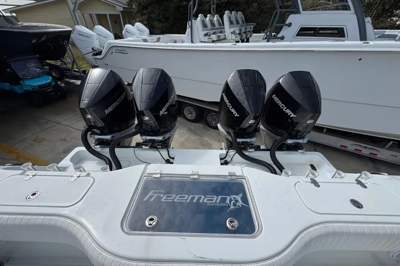 Slide: The Image of Four Mercury outboard engines on a 2016 Freeman 37VH boat, docked near other vessels. - 41