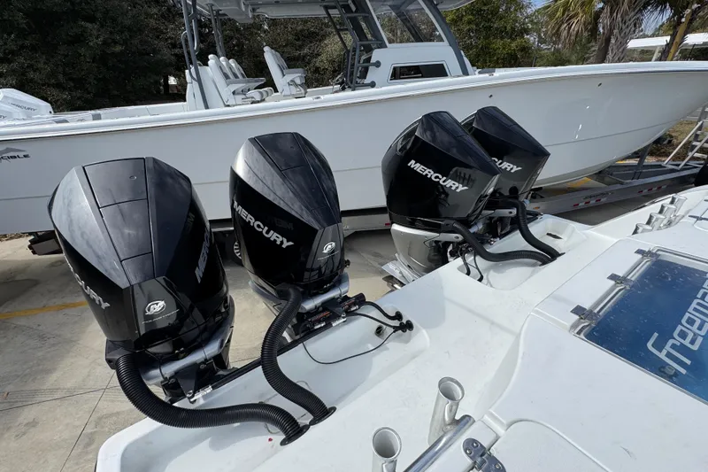 Slide: The Image of Four Mercury outboard engines on a 2016 Freeman 37VH boat, parked on a trailer. - 43